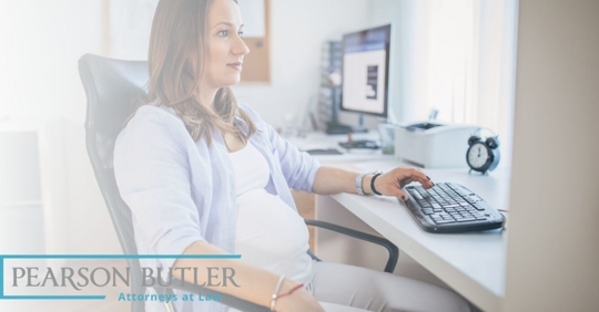 Pregnant woman typing on a computer